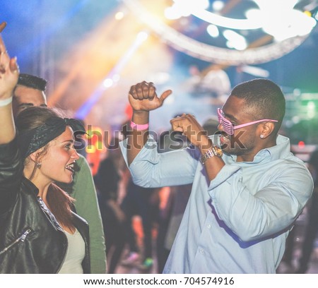 Young friends dancing at party in night club - Soft focus on black man