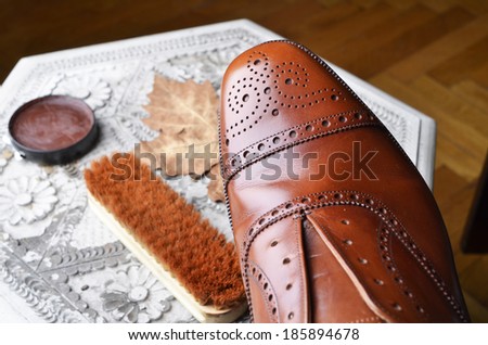 Brown leather shoes on table with polishing equipment