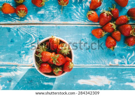 Strawberries on old rustic wooden table, vintage style photo