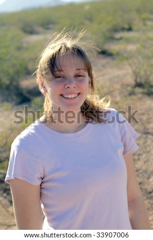 Beautiful girl shot from the waste up with back lighting in the desert