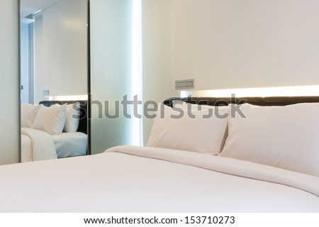Luxury White Bedroom With Reflexion View In Mirror.