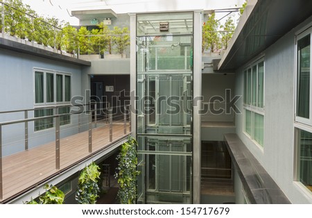 apartment interior with walkway bridge and glass lift.