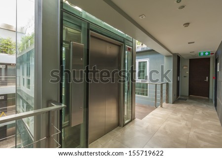 apartment interior with walkway and glass lift.