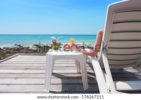 girl relaxing with healthy fruits and drink in the tropical atmosphere of koh larn island ,thailand.