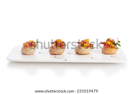 Scallop soaked with fresh yellow mango salsa, isolated on white.