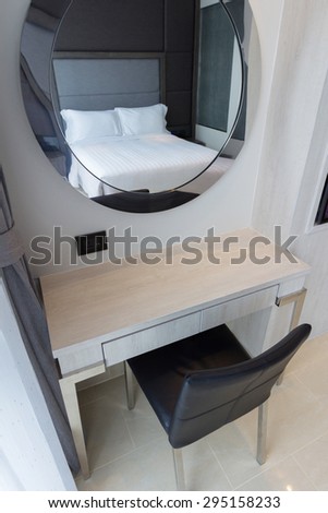 makeup table and oval mirror in bedroom.