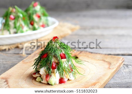 Salad Christmas tree. Salad with meat, mushrooms, cucumbers and eggs decorated with dill and pomegranate. Christmas appetiser. Old wooden background with copy empty space for text