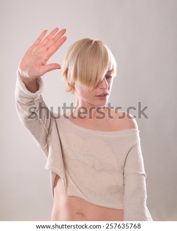 the blonde girl with short hair holding a hand in protest isolated on the white background