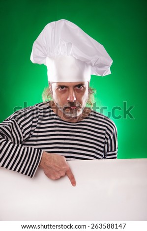 the man with gray beard in a sailor suit and hat chef  points a finger at the white  billboard isolated on the green background