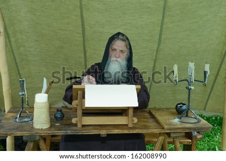 Bearded monk chronicler writes on the historic festival ancient scroll