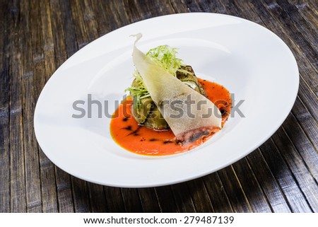 cooked fish in a plate decorated with verdure