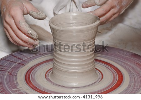 Clay in the potter\'s wheel and hand