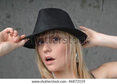 Blonde woman holding hands black hat