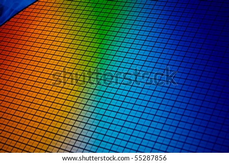 detail of a silicon chip wafer reflecting different colors