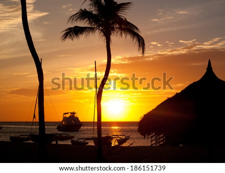 The sun is setting across the ocean waters of Palm Beach in the town of Noord.