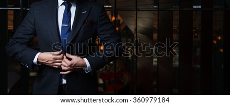 Man in suit buttoning his jacket