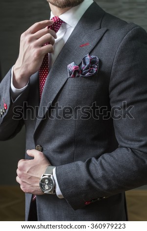 Suited man fixing his tie