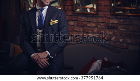 Suited man posing in a bar
