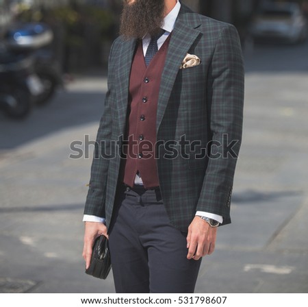 Male model in a suit and a man bag posing