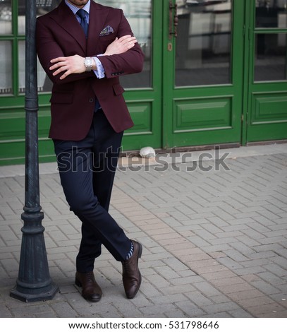 Male model in a suit posing in front of a bar