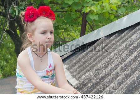 Child in the fresh air .  Happy childhood. Cheerful girl. ht clothes. Bring Emotions of happiness and pleasure . Clothes in peas . Active child. To climb on a roof.  Conversation good luck on a roof
