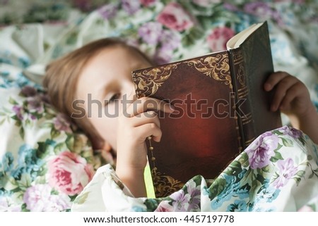 The child reads east fairy tales. To read the book. Color pastel linen. Development of the child. Clever child .  Fairy tales for the nigh t . Happy childhood .To read lying in a bed