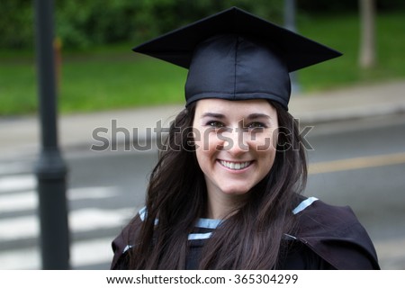 Young woman with beautiful smile in graduation gown.