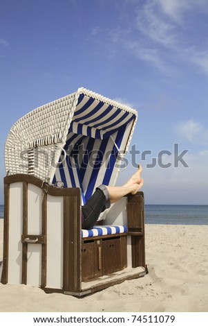 One beach chair with the feet of a woman