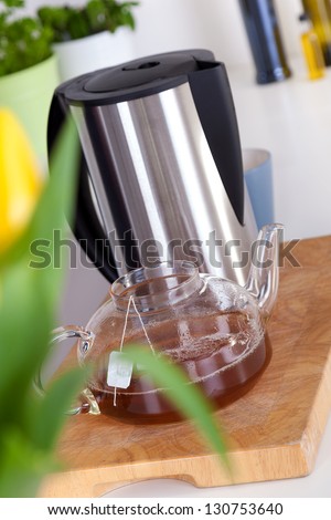 glass teapot and electric kettle on a kitchen counter