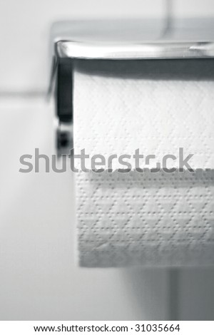 Toilet paper on a holder hanging on the wall