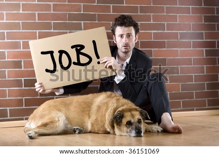 desperate businessman sits with a dog on the floor and holds a 