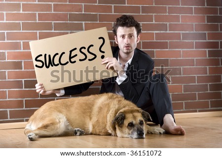 desperate  businessman sits with a dog on the floor and holds a \