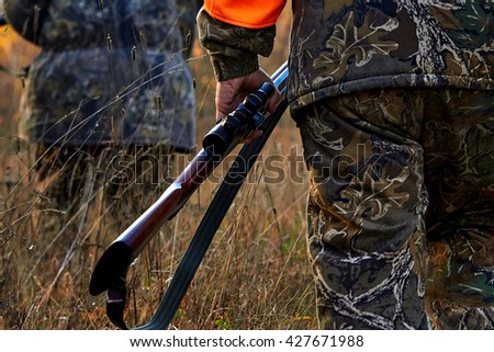 Hunter in camouflage clothes  with hunting rifle. Hunting in the forest