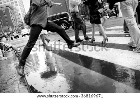 UNION SQUARE, NEW YORK, NEW YORK - Jun 14 2011: A man leaps over a puddle in Union Square.