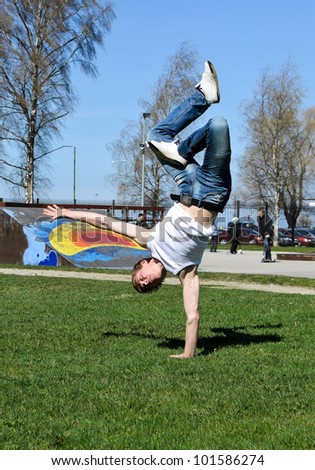 Breakdancer doing a flip on the grass.
