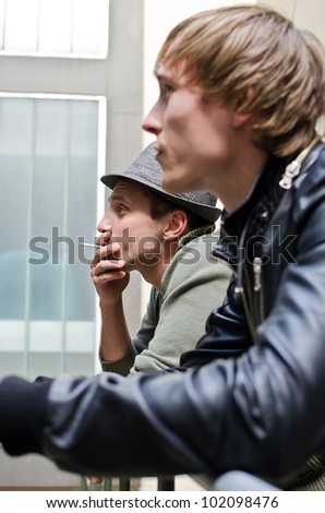 Tough guys. Portrait of two man standing on balcony