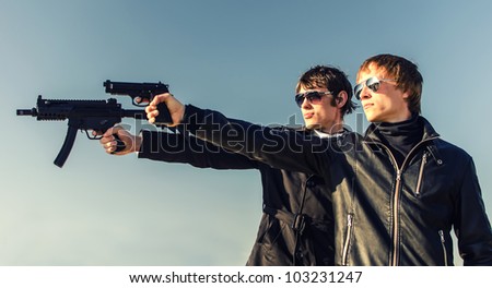 Portrait of two tough guys with guns