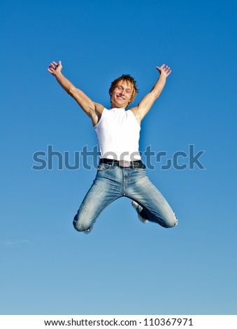 Happy jumping man on blue sky background