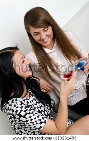 Two female friends drinking cocktail