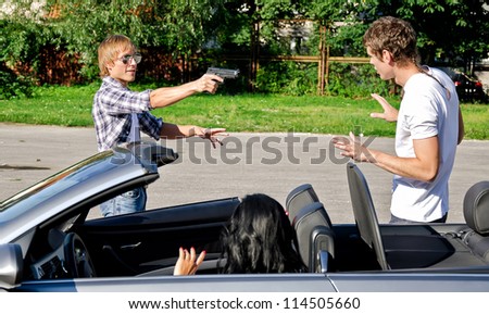 Bandit with a gun threatening young couple in the car