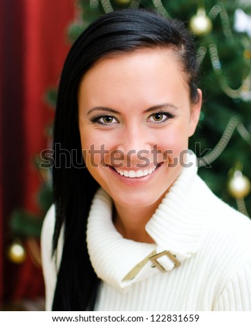 Young smiling woman portrait on christmas tree background
