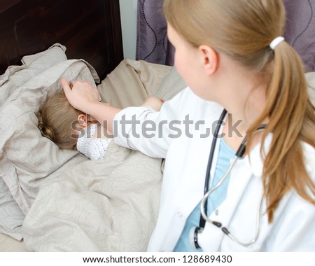 Top view of sick child lying in bed and visiting her doctor
