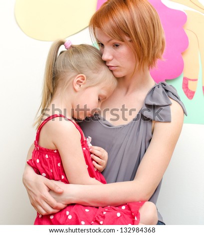 Mother huging her sad child