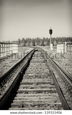Empty railroad track with semaphore signal. Black and white.