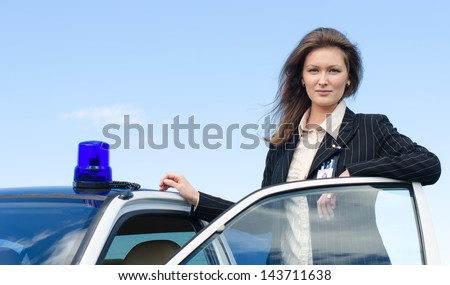 Young female FBI agent standing near car open door