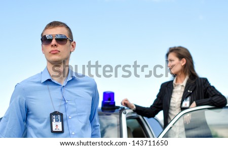 Two FBI agents near the car with flasher