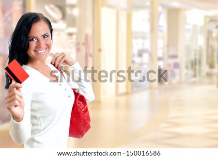 Young pretty woman in shopping center with credit card