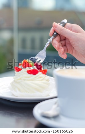 Coffee cup and creamy cake with berries