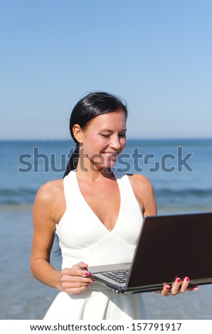 Attractive woman with notebook on the beach. Place for text
