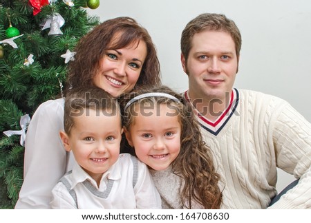 Happy family members sitting over christmas tree
